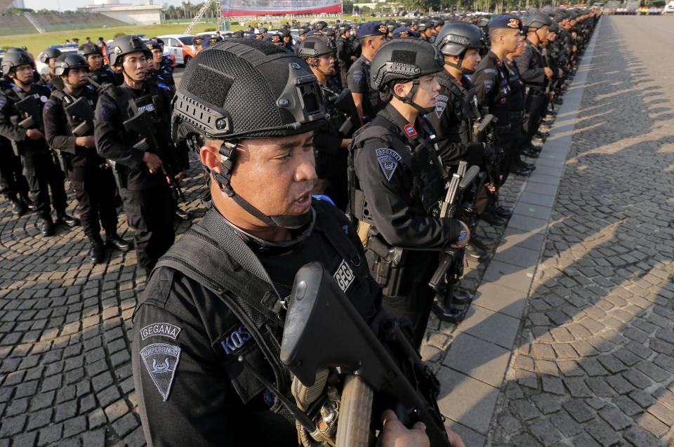 Police officers of elite unit Mobile Brigade stand in attention during a show of force ahead of Eid al-fitr holiday in Jakarta, Indonesia, Tuesday, May 28, 2019. Four top Indonesian officials, including two Cabinet ministers and the national spy chief, were targeted for assassination as part of a plot possibly linked to last week's election riots, police said Tuesday. (AP Photo/Tatan Syuflana)
