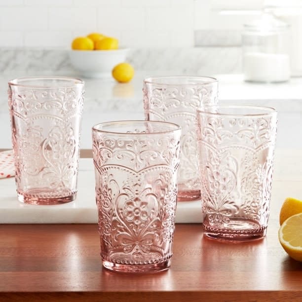 four rose colored glass tumblers on a table