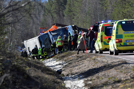 Rescue workers are seen at the site where a bus carrying school children and adults rolled over on a road close to the town of Sveg, in northern Sweden April 2, 2017. TT News Agency/Nisse Schmidt/via REUTERS