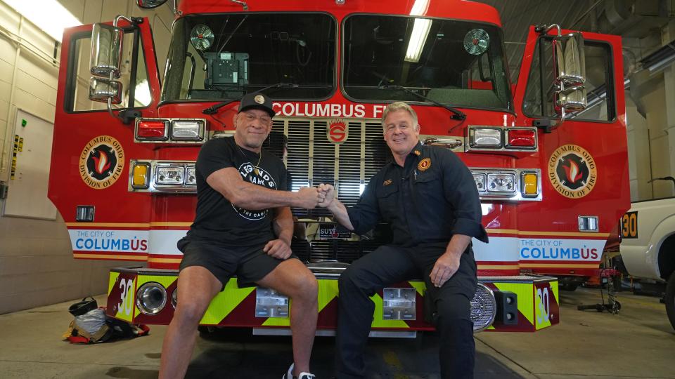Mark "The Hammer" Coleman, left, a former OSU wrestler and UFC fighter who was injured in a house fire earlier this year, first bumps his friend and Columbus Fire Chief Jeff Happ. Coleman stopped by Columbus Fire Station 30 to talk fire safety and the importance of smoke detectors. Coleman and Happ competed as wrestlers in high school and have been friends since.
