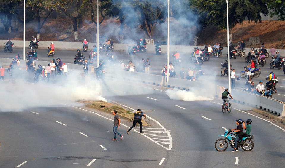 People react to tear gas near the Generalisimo Francisco de Miranda Airbase "La Carlota", in Caracas, Venezuela April 30, 2019. (Photo: Carlos Garcia Rawlins/Reuters)