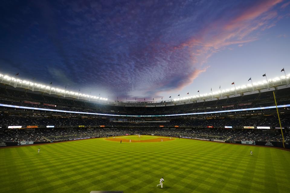 The New York Yankees play the Toronto Blue Jays under a pastel color sky during the fifth inning of the second game of a baseball doubleheader Thursday, May 27, 2021, in New York. (AP Photo/Frank Franklin II)