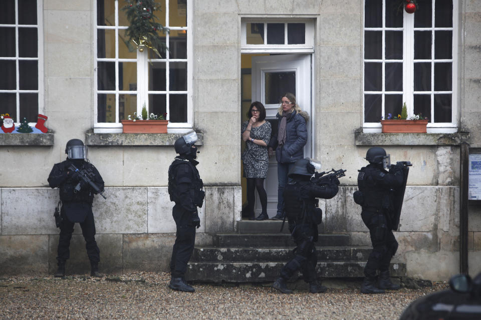 FILE - In this Jan. 8, 2015 file photo, French riot officers patrol in Longpont, north of Paris, France. The January 2015 attacks against Charlie Hebdo and, two days later, a kosher supermarket, touched off a wave of killings claimed by the Islamic State group across Europe. Seventeen people died along with the three attackers. Thirteen men and a woman accused of providing the attackers with weapons and logistics go on trial on terrorism charges Wednesday Sept. 2, 2020. (AP Photo/Thibault Camus, File)