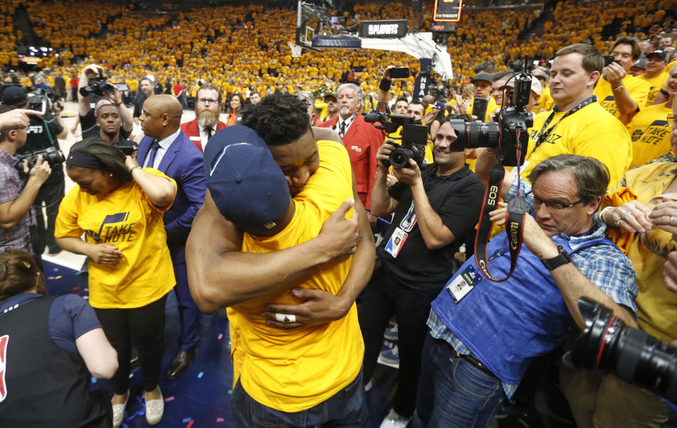 FILE - In this April 27, 2018, file photo, Utah Jazz guard Donovan Mitchell, center, hugs his father as he walks off the court following Game 6 of an NBA basketball first-round playoff series in Salt Lake City. Mitchell Sr., who works for the New York Mets, has tested negative for the coronavirus. Mitchell Sr. is the Mets’ director of player relations and community outreach. The younger Mitchell confirmed Thursday, March 12, 2020, he tested positive for the virus after Jazz teammate Rudy Gobert became the first NBA player to test positive, with Gobert's result prompting the league to suspend the season. (AP Photo/Rick Bowmer, File)