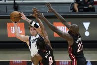 Dallas Mavericks guard Luka Doncic, left, passes past Miami Heat forward Trevor Ariza (8) and center Dewayne Dedmon (21) during the first half of an NBA basketball game, Tuesday, May 4, 2021, in Miami. (AP Photo/Wilfredo Lee)