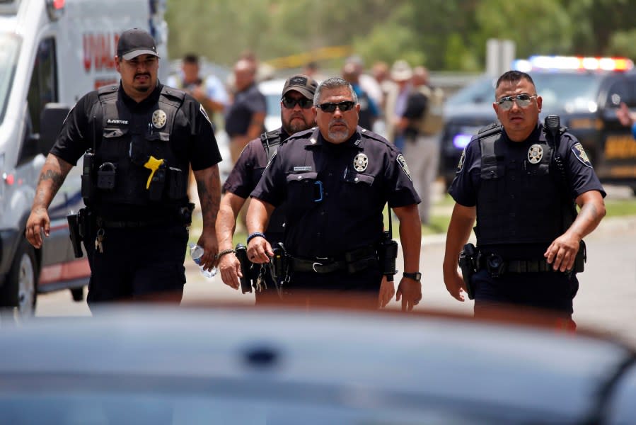 FILE — Police walk near Robb Elementary School following a shooting, May 24, 2022, in Uvalde, Texas. A federal report into the halting and haphazard law enforcement response to a school shooting in Uvalde, Texas, was scheduled to be released Thursday, Jan. 18, 2024, reviving scrutiny of the hundreds of officers who responded to the 2022 massacre but waited more than an hour to confront and kill the gunman. (AP Photo/Dario Lopez-Mills, File)