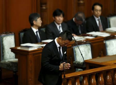 Japan's lawmaker Taro Yamamoto of the People's Life Party & Taro Yamamoto and Friends prays with Buddhist prayer beads before a voting censure motion of Japan's Prime Minister Shinzo Abe during the plenary session at the Upper House of the parliament in Tokyo September 18, 2015. REUTERS/Yuya Shino