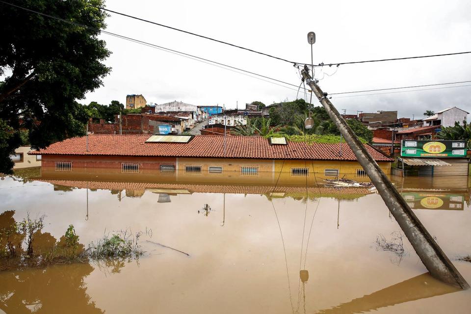 Um poste de luz inclinado é visto durante uma forte enchente em 26 de dezembro de 2022 em Idabedinga, na província da Bahia, no Brasil.