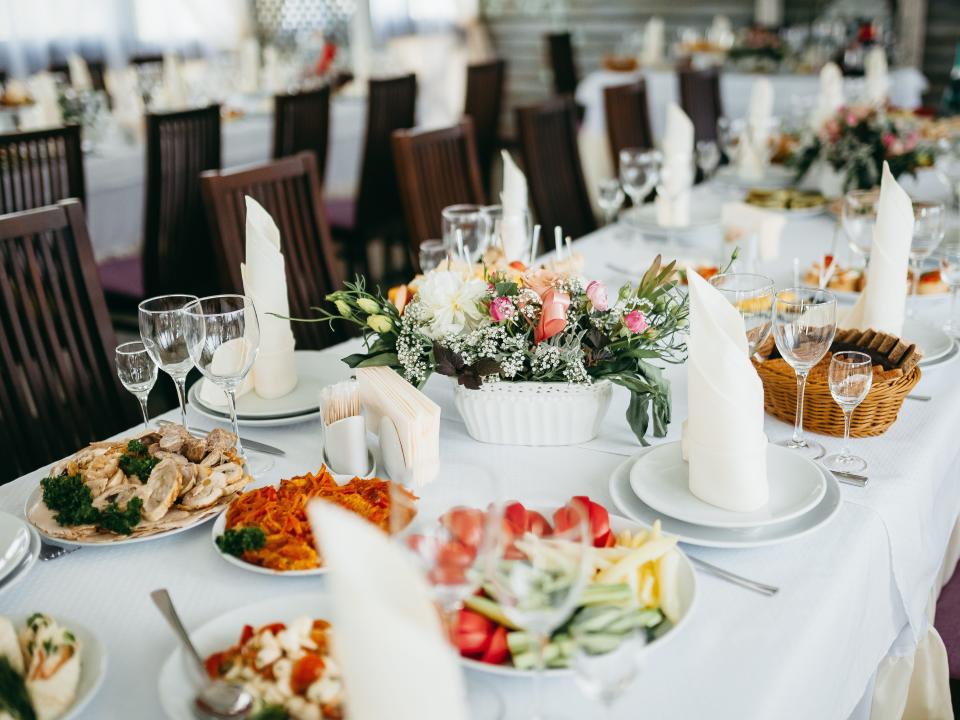 a table set with food, flowers and napkins at a wedding table