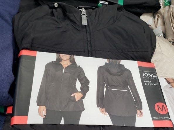 Costco black women's jacket on pile of other clothes