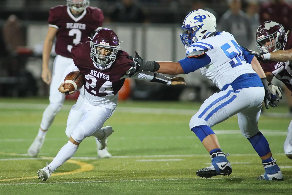 Beaver's Drey Hall (24) slips away from South Park's Antonio Loukas (54) during the first half Friday night at Pat Tarquinio Field in Beaver, PA.