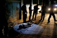 <p>Police investigate the body of Herman Cunanan, whom police said was killed by men on two motorcycles, in Quezon city, Metro Manila, Philippines, Oct. 19, 2016. Cunanan was a drug user, according to his unidentified live-in partner (Erik De Castro/Reuters) </p>