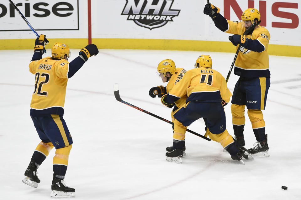 Nashville Predators' Ryan Ellis (4), Ryan Johansen (92), and Roman Josi (59), of Switzerland, celebrate with Mikael Granlund (64), of Finland, after Granlund scored the game-tying goal in the third period of an NHL hockey game against the Calgary Flames, Thursday, Feb. 27, 2020, in Nashville, Tenn. (AP Photo/Mark Zaleski)