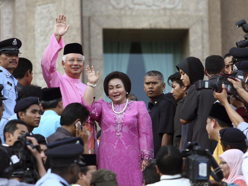 FILE - Then Malaysian Prime Minister Najib Razak, left in pink, waves with his wife Rosmah Mansor at prime minister's office in Putrajaya, outside Kuala Lumpur, Malaysia on April 3, 2009. Former first lady Rosmah was convicted Thursday, Sept. 1, 2022, of soliciting and receiving bribes during her husband’s corruption-tainted administration Thursday, a week after her husband was imprisoned over the massive looting of the 1MDB state fund. (AP Photo, File)