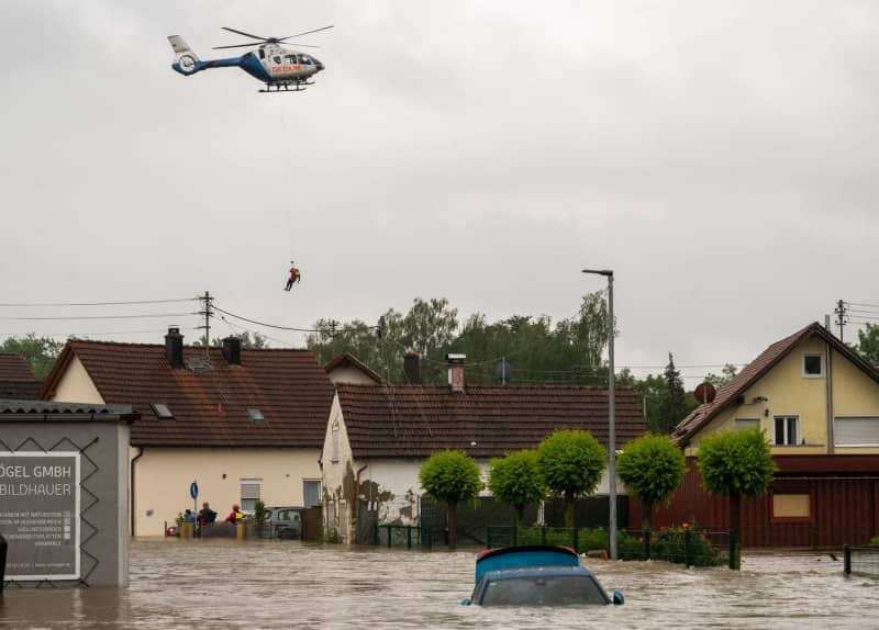 A police helicopter flies over a flooded residential area. The region has become inundated as a result of recent heavy rainfall. Stefan Puchner/dpa