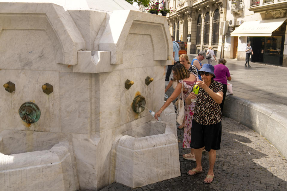 Residents and tourists fill up their water bottles from a public fountain in Belgrade, Serbia, Friday, June 21, 2024. A major hourslong power outage hit much of the Balkans on Friday as the southern European region sweltered in an early heat wave that sent temperatures soaring to more than 40 C (104 F). (AP Photo/Darko Bandic)