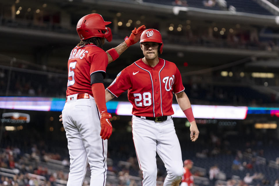 Washington Nationals' CJ Abrams, left, celebrates with teammate Lane Thomas, right, after both score on a double hit in by Nationals' Keibert Ruiz during the third inning of the second game of a baseball doubleheader against the Atlanta Braves, Sunday, Sept. 24, 2023, in Washington. (AP Photo/Stephanie Scarbrough)