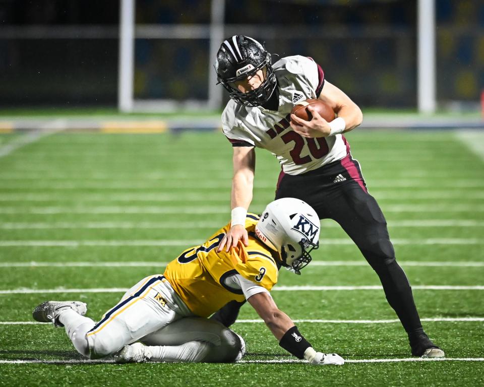 Badger quarterback JP Doyle tries to avoid the tackle of Kettle Moraine’s Noah Hait in their WIAA Division 2 state quarterfinal playoff game Friday night.
