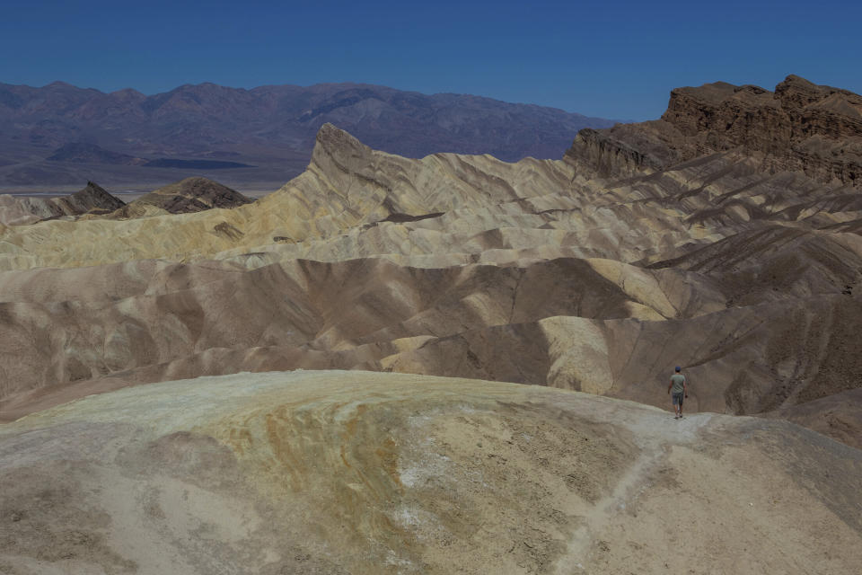 Un hombre camina por un sendero del cañón Golden en el Parque Nacional Valle de la Muerte, California, el martes 11 de julio de 2023. Julio es el mes más caluroso en el parque, con una temperatura máxima promedio de 46,5 grados Celsius (116 grados Fahrenheit). (AP Foto/Ty ONeil)