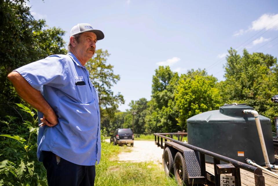 Phillip Everett, superintendent of the Lake Livingston Water Supply Corporation, stands at a trailer containing a water tank located the entrance of Sam Houston Lakes Estates, a neighborhood that has been lost to flooding, on June 27, 2023.