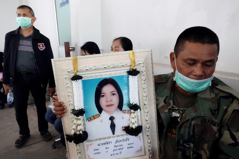 A relative holds a picture of Patchara Chanpeng, a victim of a gun battle involving a Thai soldier on a shooting rampage at a hospital in Nakhon Ratchasima