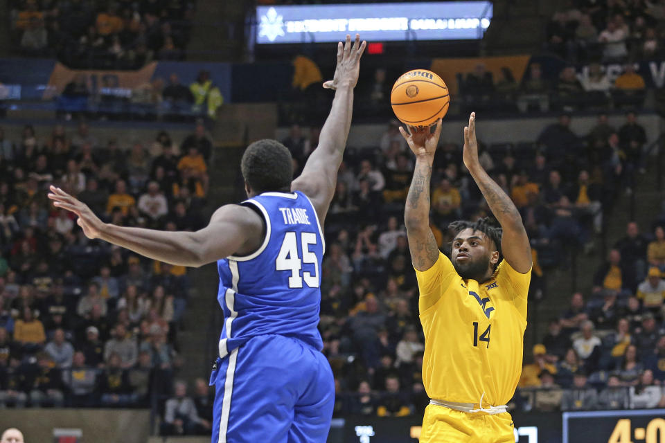 West Virginia guard Seth Wilson (14) is defended by BYU forward Fousseyni Traore (45) during the second half of an NCAA college basketball game Saturday, Feb. 3, 2024, in Morgantown, W.Va. (AP Photo/Kathleen Batten)