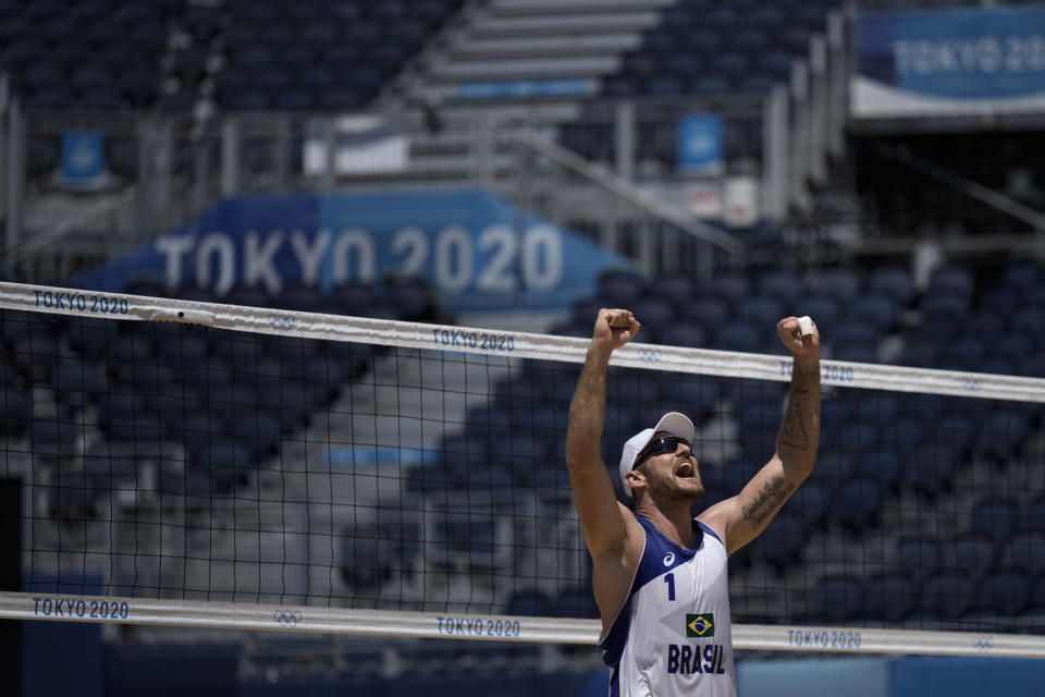 Alison Cerutti, of Brazil, celebrates after winning a men's beach volleyball match against Argentina at the 2020 Summer Olympics, Saturday, July 24, 2021, in Tokyo, Japan. (AP Photo/Felipe Dana)