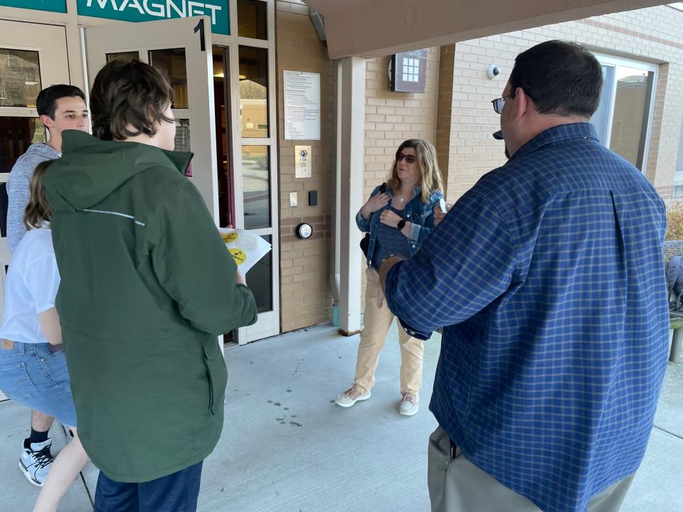 Students from Norwich Free Academy gave stickers in support of music programs to attendees of Tuesday's Norwich Board of Education meeting. Three music teacher positions, among many others, were cut for budget reasons.