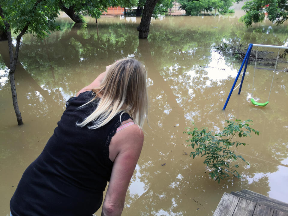 Lori Grantham of Horseshoe Bend points to flooded homes where residents are staying put. “Some people refuse to leave,” she said. (Yahoo News/Jason Sickles)