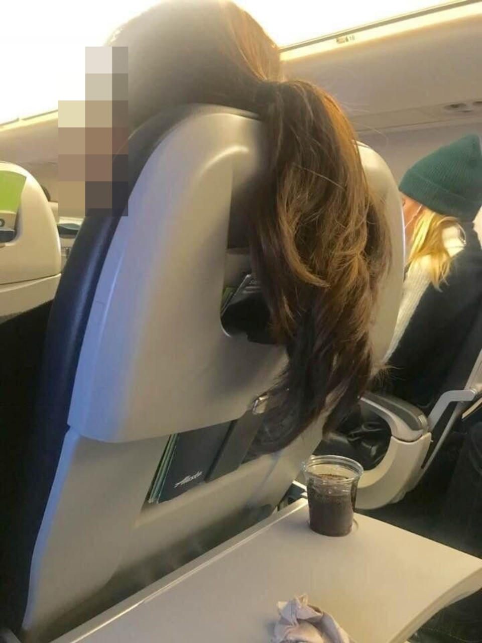 Someone's hair hanging over their seat