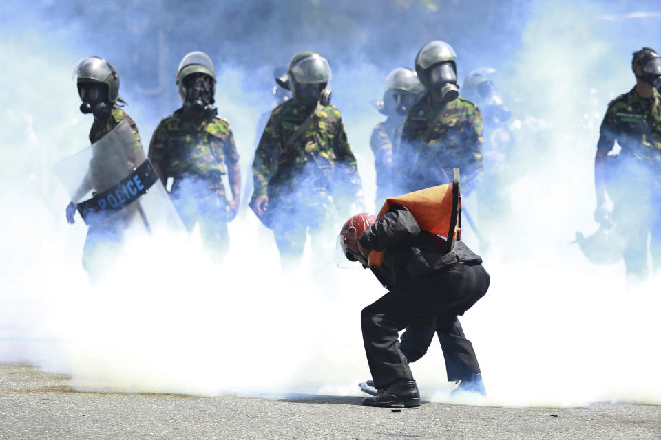 FILE - A man picks up a tear gas canister to throw it away after police fired it to disperse the protesters in Colombo, Sri Lanka, Saturday, July 9, 2022. The street protests that drove Sri Lanka’s President Gotabaya Rajapaksa from office last month brought together people from across the country’s diverse and sometimes warring ethno-religious groups: Tamils, Muslims, Christians and Sinhala Buddhists — including, unmistakably, the saffron-robed Buddhist monks who are fixtures of Sri Lanka’s political scene. (AP Photo/Amitha Thennakoon, File)