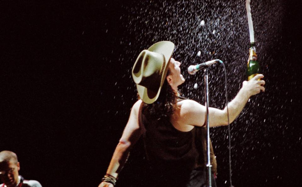 U2 frontman Bono sprays the Wembley crowd with champagne - Redferns