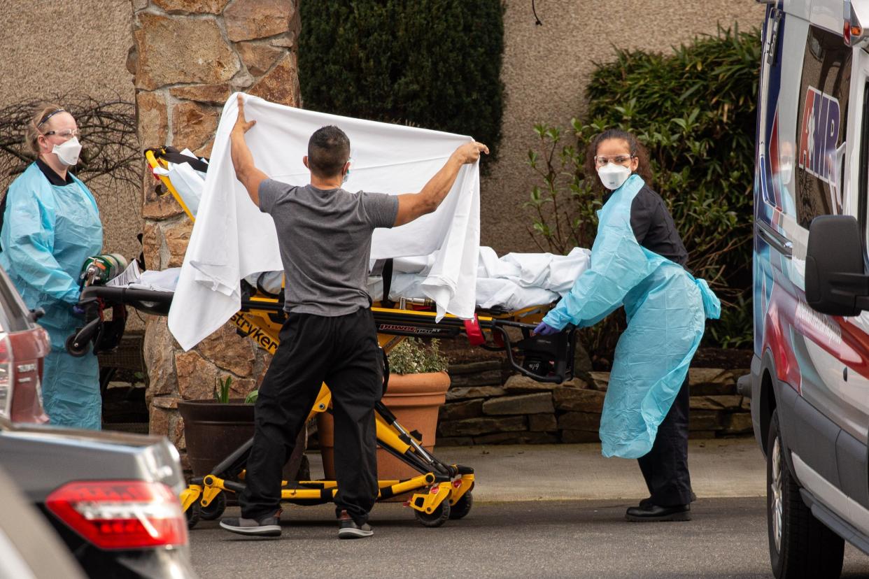 Healthcare workers transfer a patient at the Life Care Center in Kirkland, Washington, into an ambulance as tests continue for the coronavirus: Getty Images