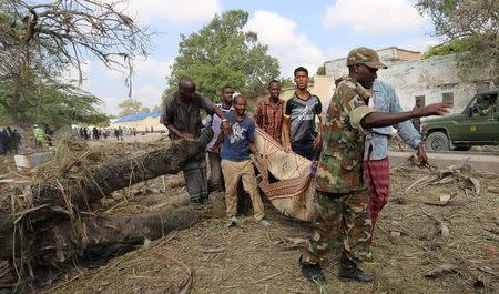 Residents carry the dead body of a man killed after a suicide car bomb went off at the entrance of Somalia's biggest port in the capital Mogadishu December 11, 2016. REUTERS/Feisal Omar