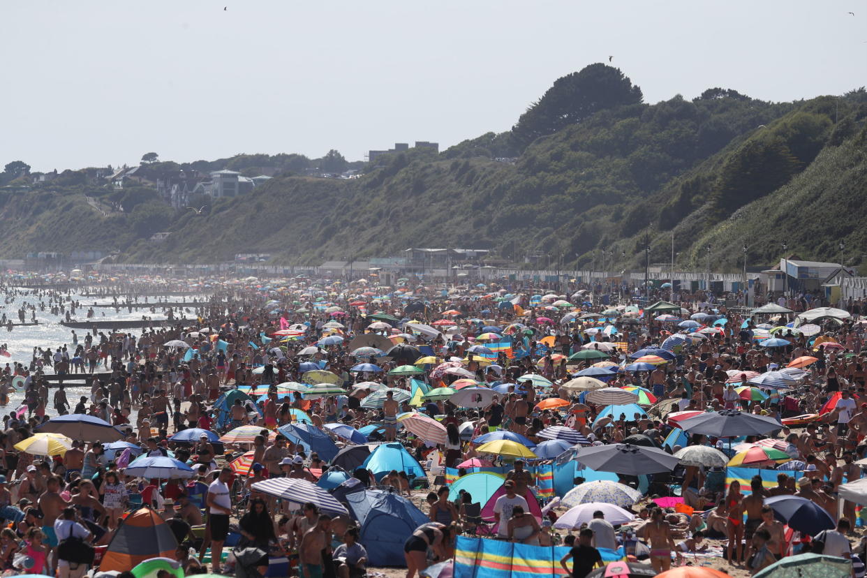 People are seen on the beach on the hottest day of the year, after an easing of social restrictions due to coronavirus, in Bournemouth, England, Wednesday, June 24, 2020. Temperatures reached 32.6C (90.7F) at London's Heathrow Airport on Wednesday. (Andrew Matthews/PA via AP)