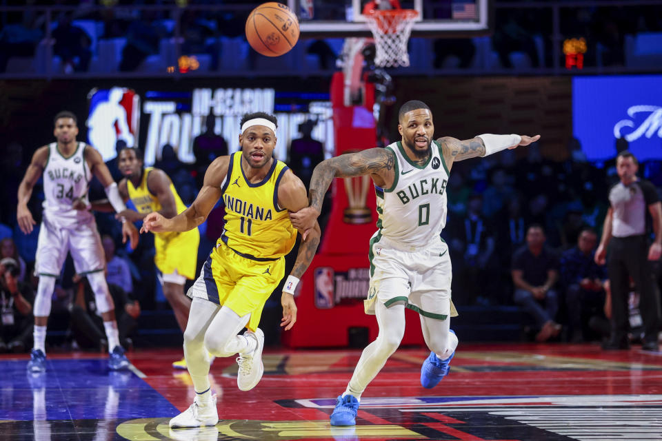 Indiana Pacers forward Bruce Brown (11) and Milwaukee Bucks guard Damian Lillard (0) watch the ball get away during the second half of a semifinal in the NBA basketball In-Season Tournament, Thursday, Dec. 7, 2023, in Las Vegas. (AP Photo/Ian Maule)