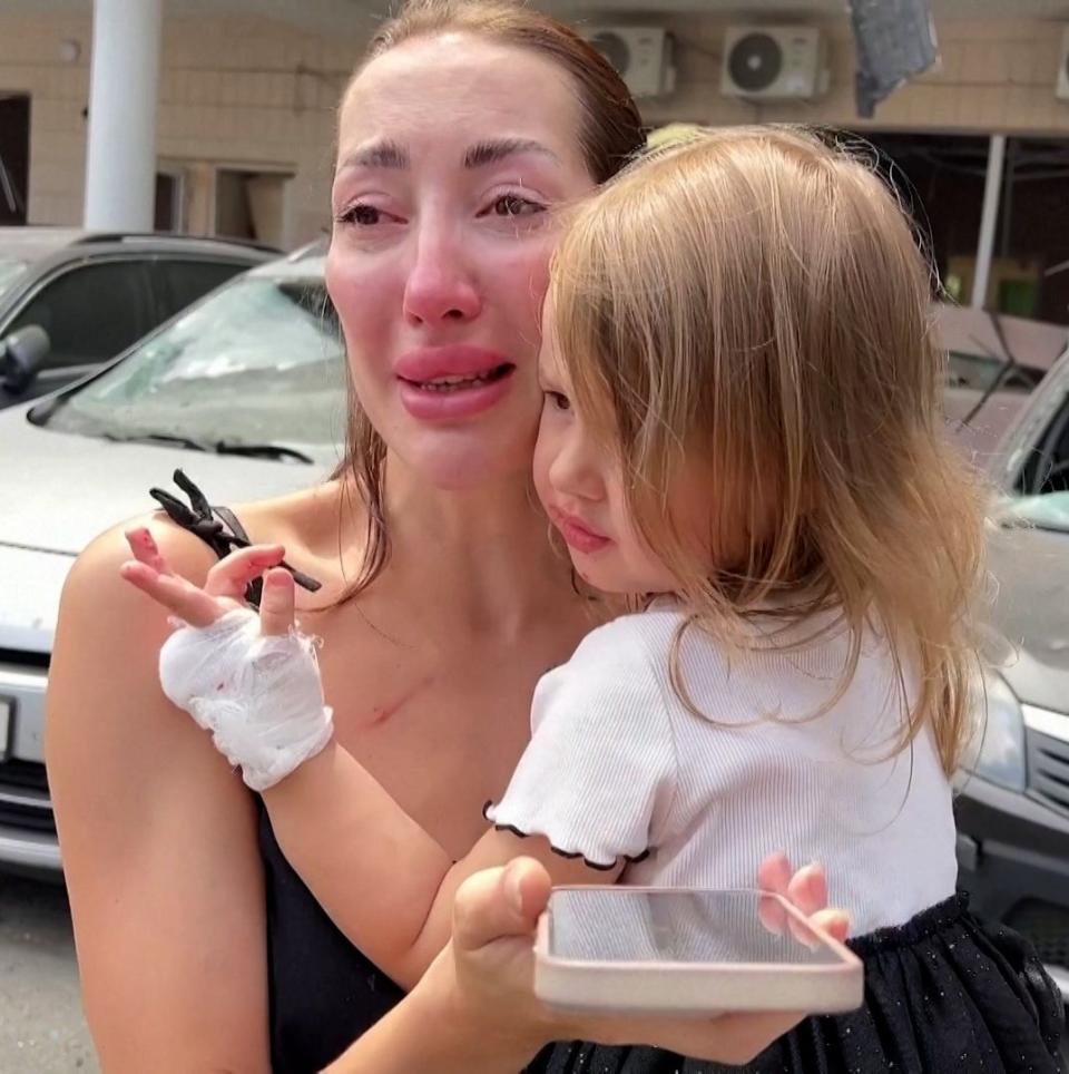 Woman holds a young child in her arms in the wake of the attack