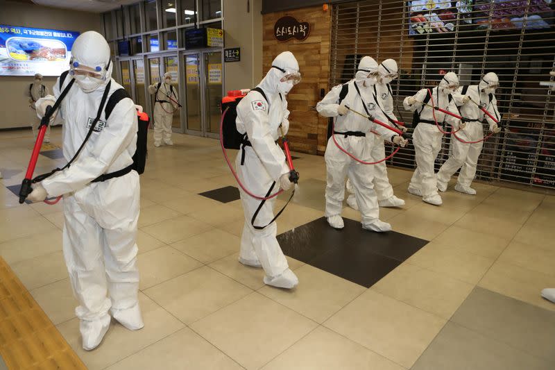 South Korean soldiers wearing protective gear sanitize Daegu railway station in Daegu