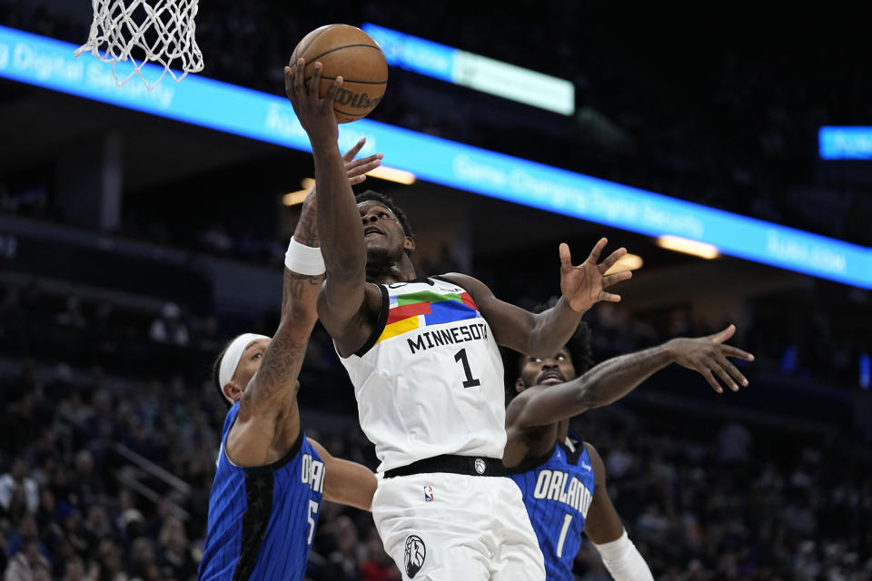 Minnesota Timberwolves shoots while fouled by Orlando Magic forward Paolo Banchero, left, during the first half of an NBA basketball game, Friday, Feb. 3, 2023, in Minneapolis. (AP Photo/Abbie Parr)