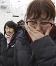 A relative of missing passengers of the sunken Sewol ferry cries as she watches workers lifting the boat in waters off Jindo, South Korea, Thursday, March 23, 2017. South Korean workers on Thursday slowly pulled up the 6,800-ton ferry from the water, nearly three years after it capsized and sank into the violent seas off South Korea's southwestern coast, an emotional moment for a country that continues to search for closure to one of its deadliest disasters ever. (Lee Jin-wook/Yonhap via AP)
