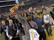 FILE - In this Sunday, Feb. 6, 2011, file photo, Green Bay Packers' Charles Woodson holds the Vince Lombardi Trophy after NFL football Super Bowl XLV in Arlington, Texas. Woodson was one of the best football players of all time, joining Hall of Fame running back Marcus Allen as the only players to win a Heisman Trophy, AP Rookie of the Year, AP Player of the Year and a Super Bowl. (AP Photo/Dave Martin, File)