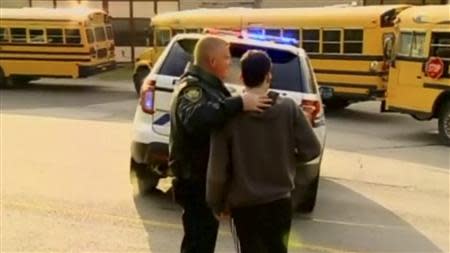 A young man speaks to a policeman outside of Franklin Regional High School after reports of stabbing injuries in Murrysville, Pennsylvania April 9, 2014, in this still image taken from video courtesy of WPXI. REUTERS/WPXI/Handout via Reuters