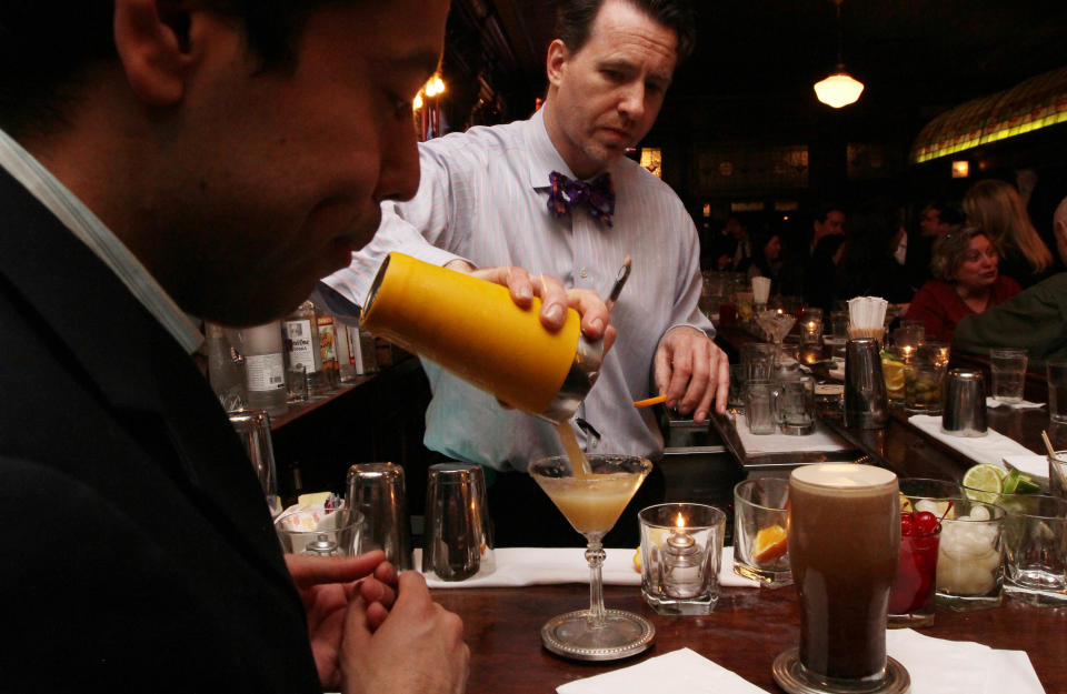 In this Thursday, March 8, 2012 photo, Doug Quinn, serves a Sidecar cocktail as he works at the bar at P.J. Clarke's in New York. P.J. Clarke’s is one of many bars and restaurants in Manhattan featured on the AMC show “Mad Men,” which returns March 25 after more than a year hiatus. The show is filmed in California but it’s set in New York, with many references to real establishments from the 1960s, some of which still exist. (AP Photo/Tina Fineberg)