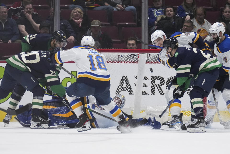 St. Louis Blues' Colton Parayko (55) clears the puck away after goalie Jordan Binnington stopped Vancouver Canucks' Curtis Lazar (20) during the third period of an NHL hockey game in Vancouver, British Columbia, on Monday, Dec. 19, 2022. (Darryl Dyck/The Canadian Press via AP)