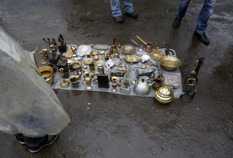 In this photo taken Saturday, Feb. 22, 2014, a street vendor, left waits for customers in downtown Lviv, western Ukraine. If Ukraine looks neatly delineated on maps, its often-bloody history is a tangle of invasions and occupations, peoples and religions. It is a place that has been struggling for centuries to define itself. And now it finds itself so sharply divided _ between allegiance to Russia on one side of the country and loyalty to the West on the other _ that it often seems more like two countries than one. (AP Photo/Darko Vojinovic)