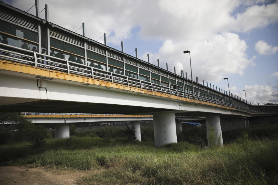 Pedestrians wait to enter Brownsville, Texas on the Puerta Mexico bridge that crosses the Rio Grande river, at a legal port of entry in Matamoros, Mexico, Thursday, Aug. 1, 2019, on the border with Brownsville, Texas. Migrants who had turned themselves over to U.S. authorities and in most cases requested asylum are returned to wait in Mexico and return to the U.S. for a court date in what is a months-long process. (AP Photo/Emilio Espejel)