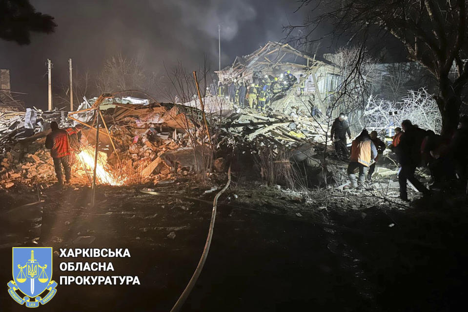 In this photo provided by Kharkiv Regional Prosecutor's Office, firefighters examine the site of Russia's missile attack that hit an apartment building in Kharkiv Region, Ukraine, Thursday, Feb. 15, 2024. (Kharkiv Regional Prosecutor's Office/ via AP)