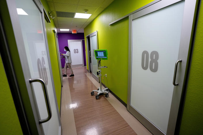 A nurse enters an exam room at the Mountain Park Health Center, Thursday, March 30, 2023, in Phoenix. As heat waves fueled by climate change arrive earlier, grow more intense and last longer, people over 60 who are more vulnerable to high temperatures are increasingly at risk of dying from heat-related causes. Heat related deaths are challenging community health systems, utility companies, apartment managers and local governments to better protect older people when temperatures soar.(AP Photo/Matt York)