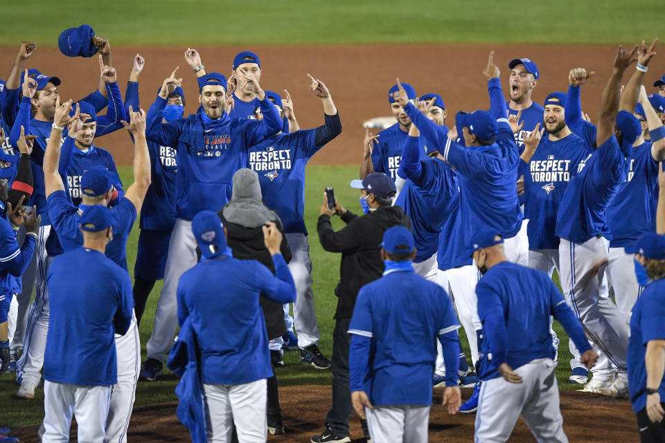 Toronto Blue Jays players, coaches and staff celebrate a 4-1 win over the New York Yankees in a baseball game in Buffalo, N.Y., Thursday, Sept. 24, 2020. Toronto clinched a postseason berth with the win. (AP Photo/Adrian Kraus)