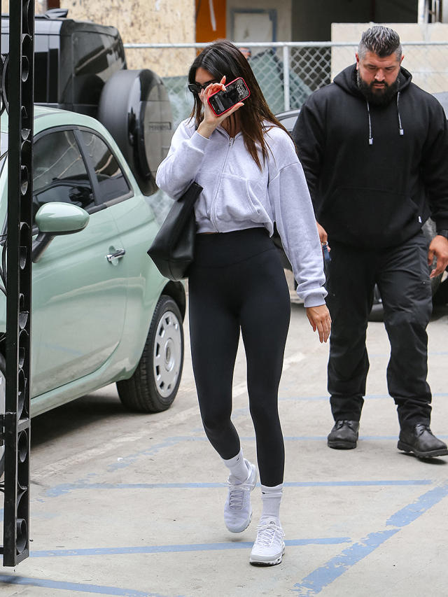 Kendall Jenner shows off her slender frame in a grey crop top and leggings  as she